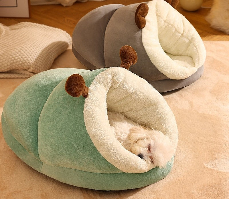 Cama Zapatilla verde y gris en el suelo del salón, con un perrito blanco dentro de la verde